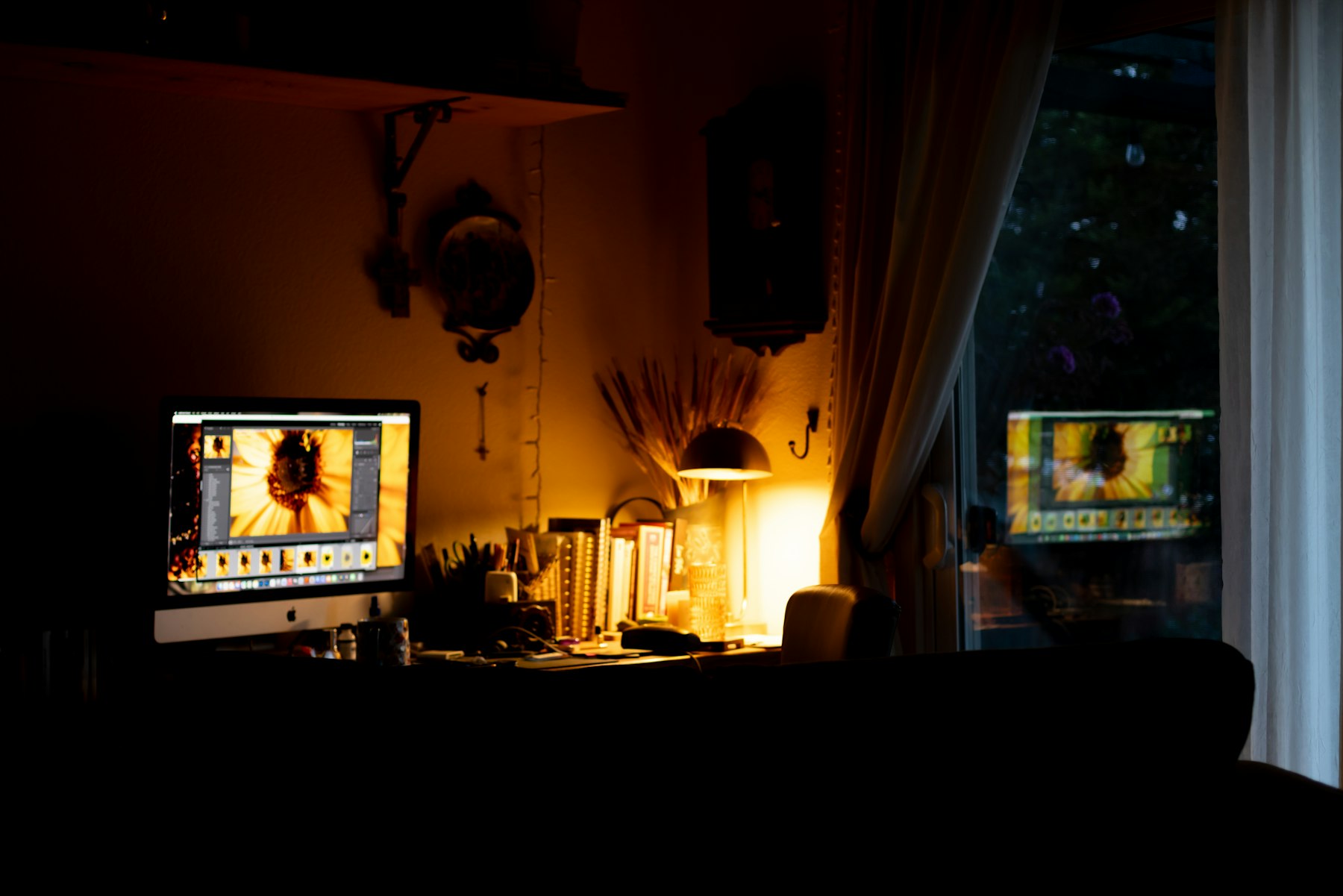 A dim studio workspace lit by warm lamps and screens